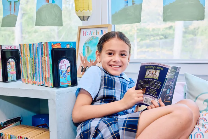 Student reading book at St. Bridget