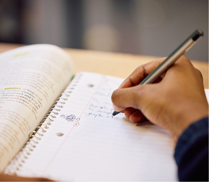 Student writing in notebook